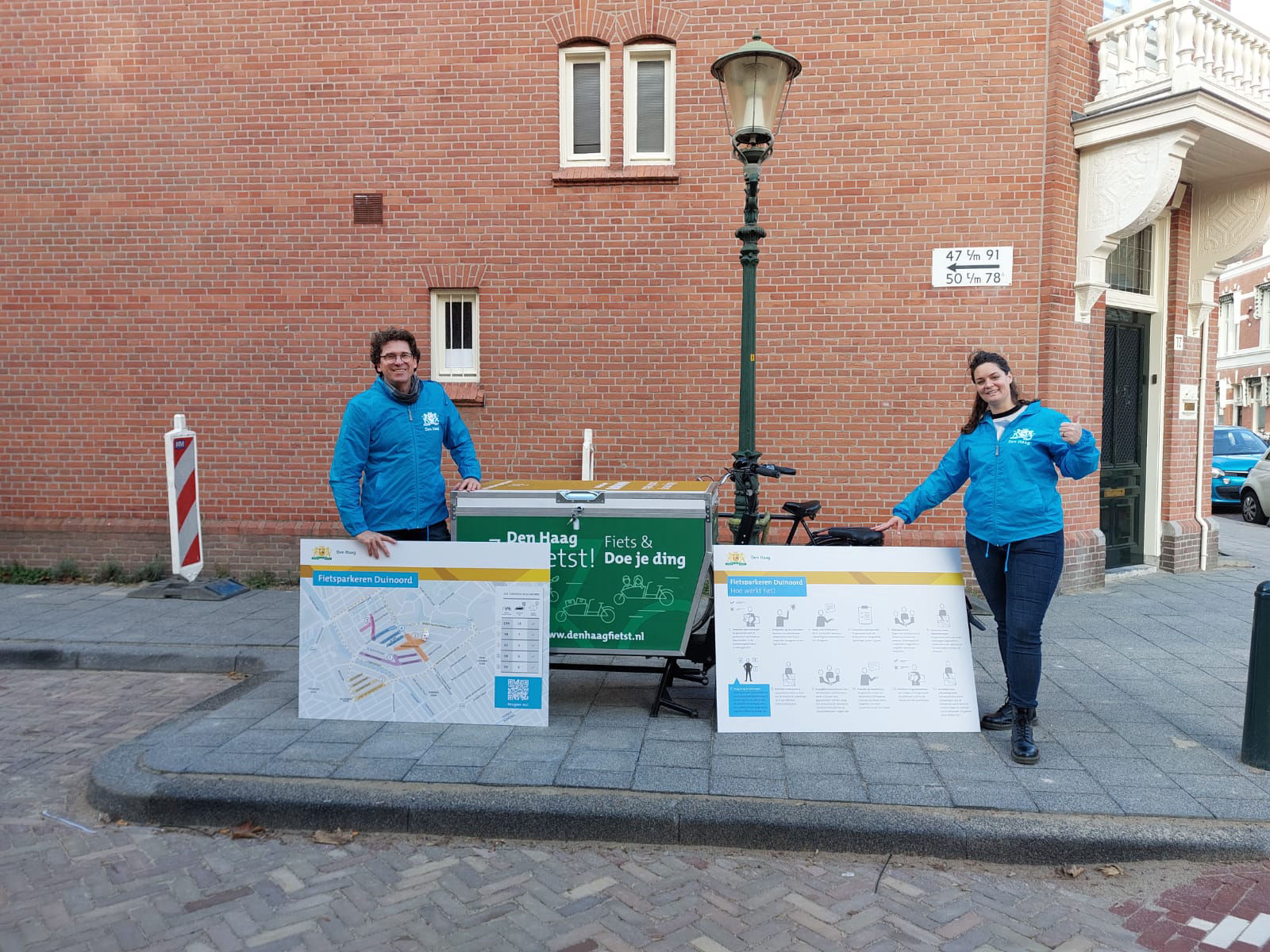 Twee ambtenaren met een koffiekar in de wijk